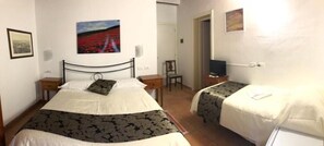 A bedroom with two beds, a chair, a TV, and a painting on the wall. - Villa Tuscany Siena  (Siena)