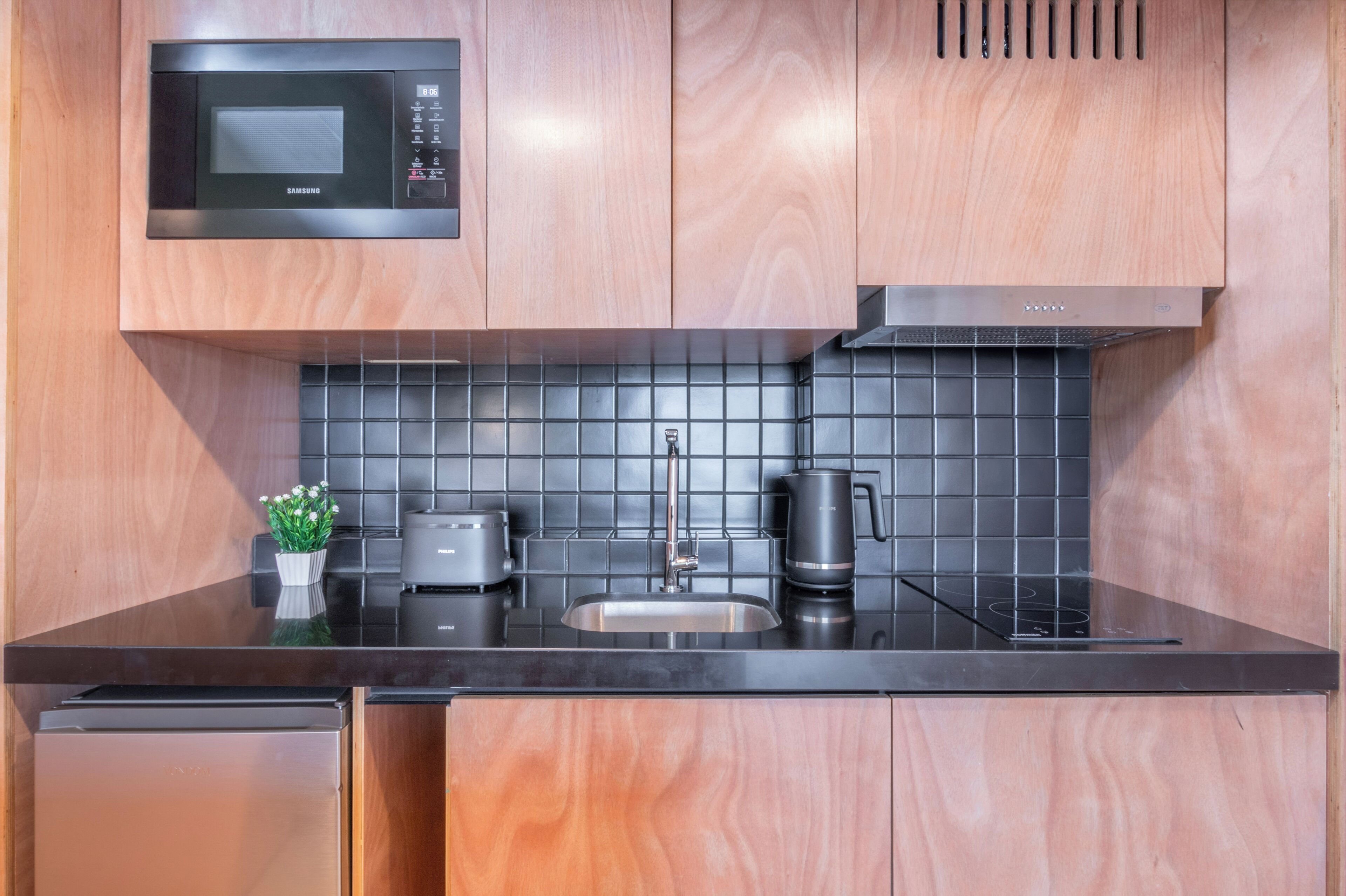 Eine moderne Küche mit Mikrowelle, Toaster, Wasserkocher und Spüle.