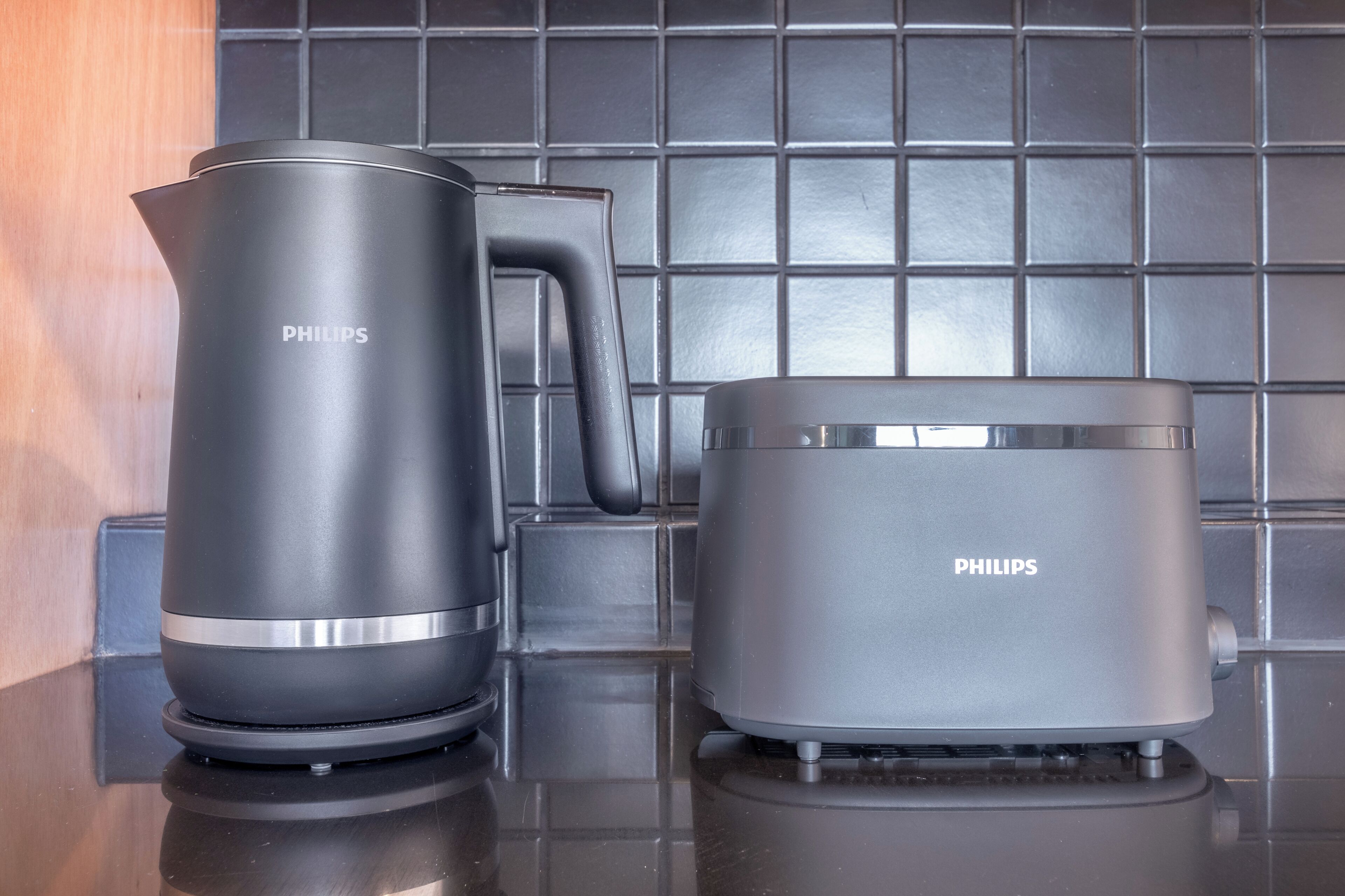 Dos hervidores eléctricos Philips sobre una encimera de cocina con salpicadero de azulejos.
