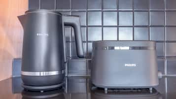 Two Philips electric kettles on a kitchen counter with a tiled backsplash.