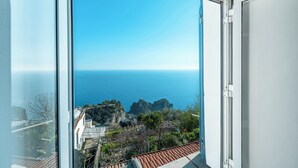 A view from a window overlooking a coastal landscape with rocky outcrops and a clear blue sky. - Casa Capo di Conca by Wonder Tour (Conca dei Marini)