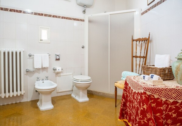 Et badeværelse med bidét, toilet og radiator.