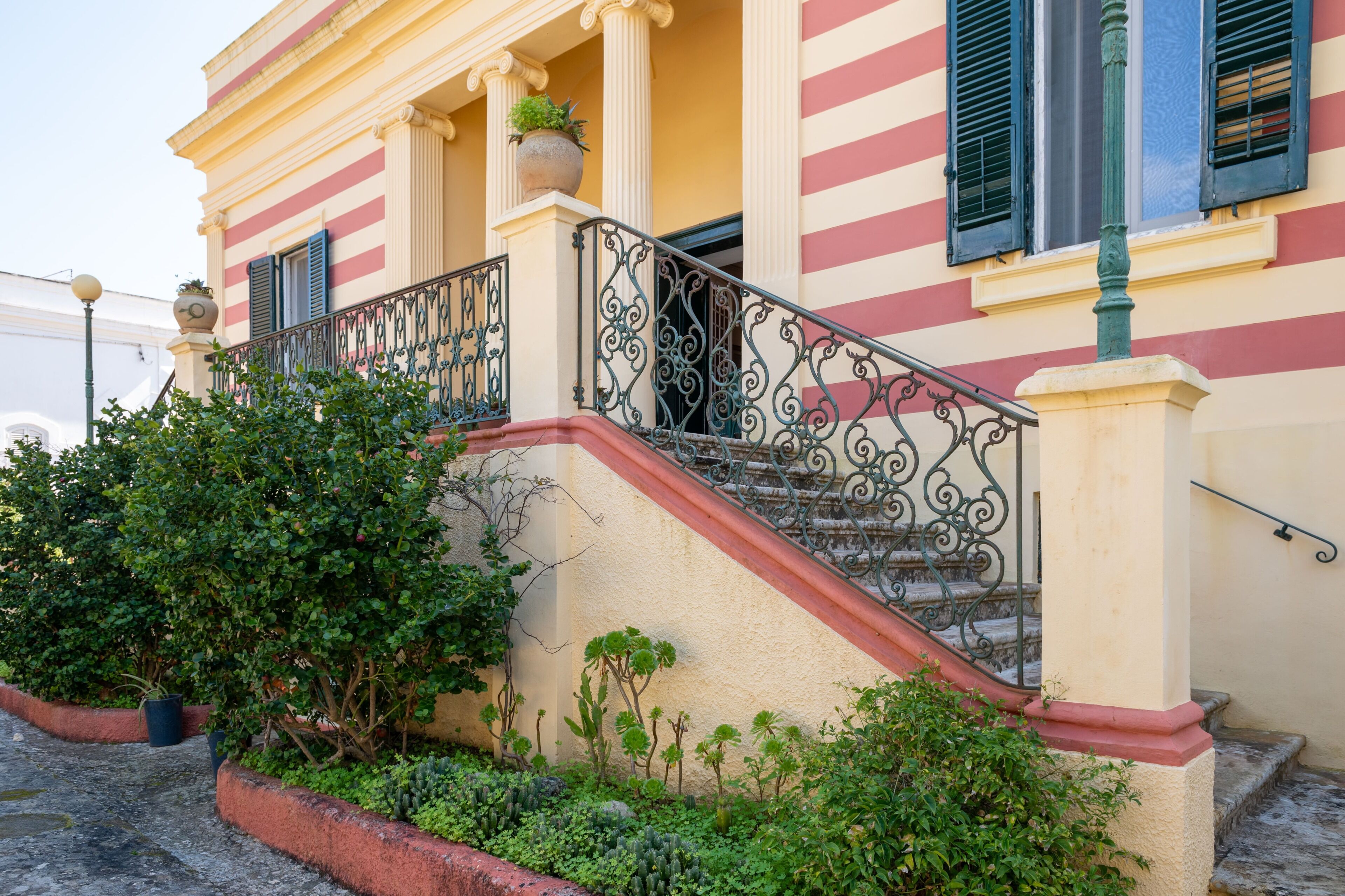 A building with a staircase, columns, and a railing.