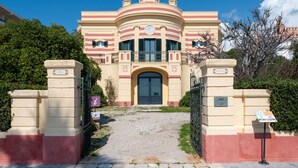 Un edificio grande e histórico con una entrada central, un reloj y una cúpula.