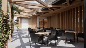 An outdoor dining area with wooden beams, tables, and chairs. - Boutique Hotel Sončno Polje (Moravske Toplice)