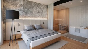 A modern bedroom with a bed, bedside tables, a floor lamp, a built-in shower, and a large mirror. - Boutique Hotel Sončno Polje (Moravske Toplice)