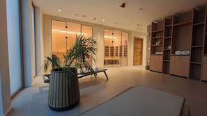 A modern interior with a large potted plant, a bench, and built-in wooden shelving. - Boutique Hotel Sončno Polje (Moravske Toplice)