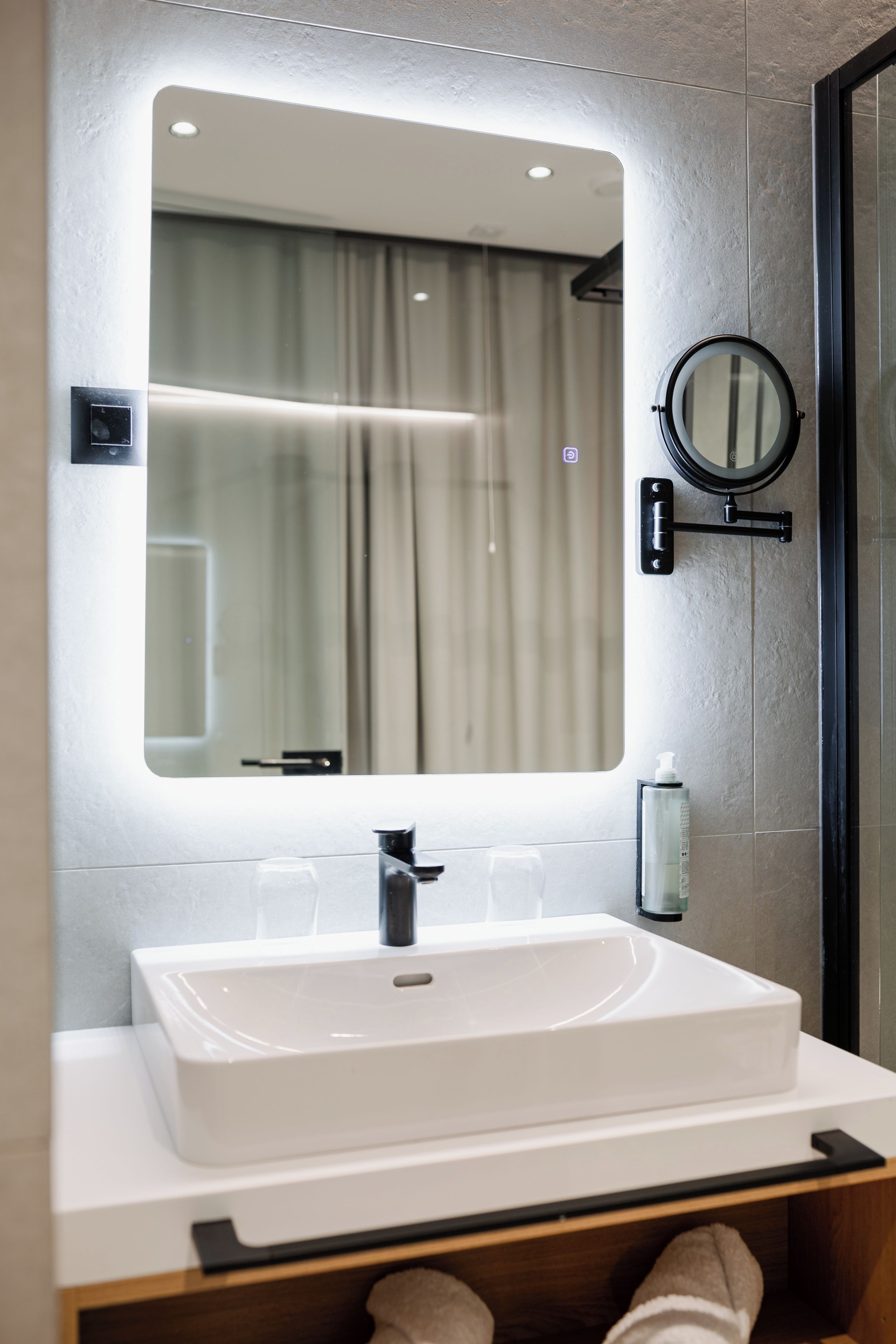 A bathroom with a large rectangular sink, a mirror, and a towel rack.
