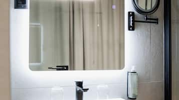 A bathroom with a large rectangular sink, a mirror, and a towel rack.