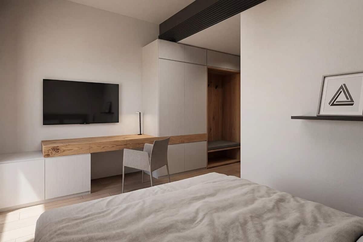 A modern bedroom with a bed, a desk, and a chair.