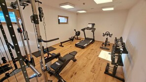 A gym with various exercise equipment including a treadmill, stationary bike, and weight machines. - Boutique Hotel Sončno Polje (Moravske Toplice)