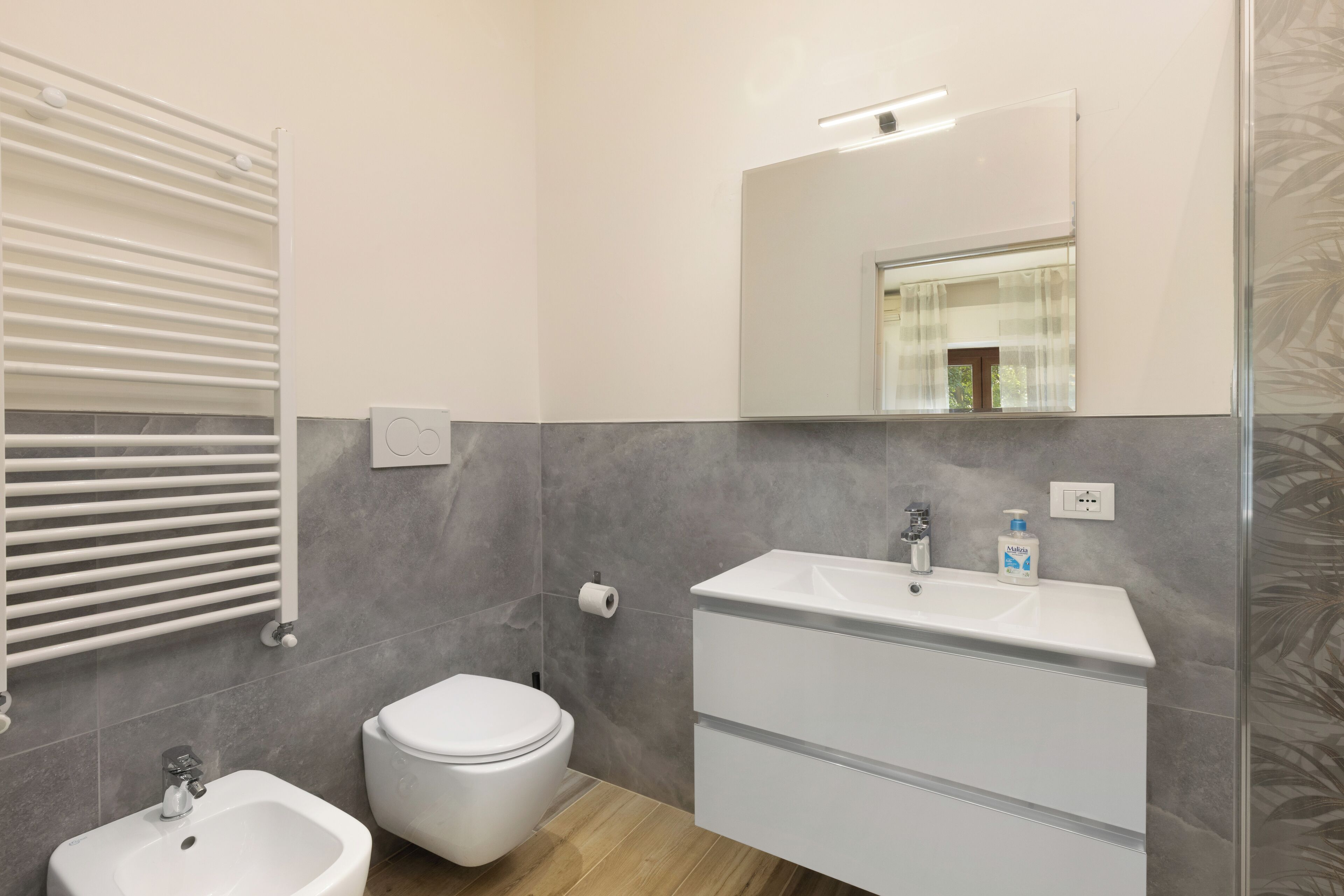 Un baño moderno con un lavamanos blanco, un inodoro y un bidé.