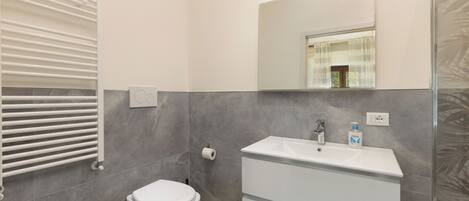 Un baño moderno con un lavamanos blanco, un inodoro y un bidé.
