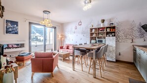 Una sala moderna con comedor, ventanas grandes y un mural temático de esquí.