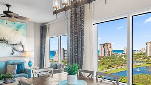 A modern dining area with a view of a cityscape and water. - 🏖️Beautiful Views - Lagoon Pool - Hot Tub - Walk2Beach - Luau I 7010/7012☀️ (Miramar Beach)