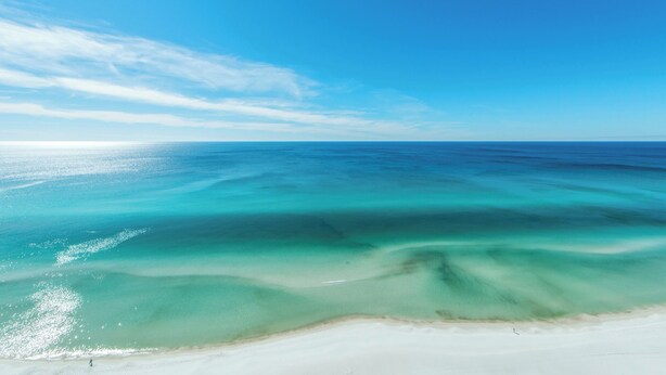 Ein Strand mit klarem türkisblauem Wasser und einem Sandstrand.