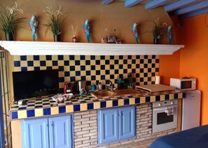 A kitchen with a checkered backsplash, blue cabinets, and a microwave. - Casa AMMIRATI Flayosc (Flayosc)