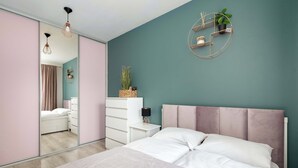 A bedroom with a bed, a dresser, a nightstand, a mirror, and a wall-mounted shelf with a plant. - Comfortable Apartment | Garden and Private Parking (Szczecin)