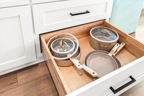Keittiönlaatikko, jossa on kolme kattilaa ja paistinpannua.