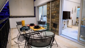 A dining area with a glass table, chairs, and a whiteboard. - Serenity and 2 bedroom Luxury in Kalamaria (Kalamaria)