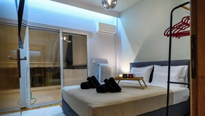 A bedroom with a bed, a radiator, a window, and a door leading to a balcony. - Serenity and 2 bedroom Luxury in Kalamaria (Kalamaria)