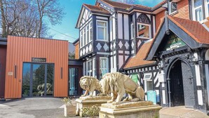 Un edificio con recepción, una estatua de león y un cartel para reservas de vacaciones.