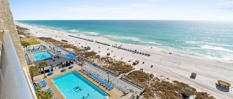 A beachfront hotel with a swimming pool, beach access, and a view of the ocean.