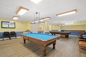 A pool table in a room with a television, chairs, and a ceiling light fixture. - Gulffront Condo w/ Tiki Bar, Pools, & Sunsets (Panama City Beach)