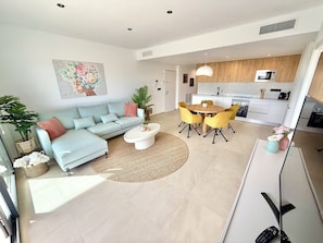 Ein modernes Wohnzimmer mit einer Couch, einem Couchtisch und einem Essbereich mit Stühlen.