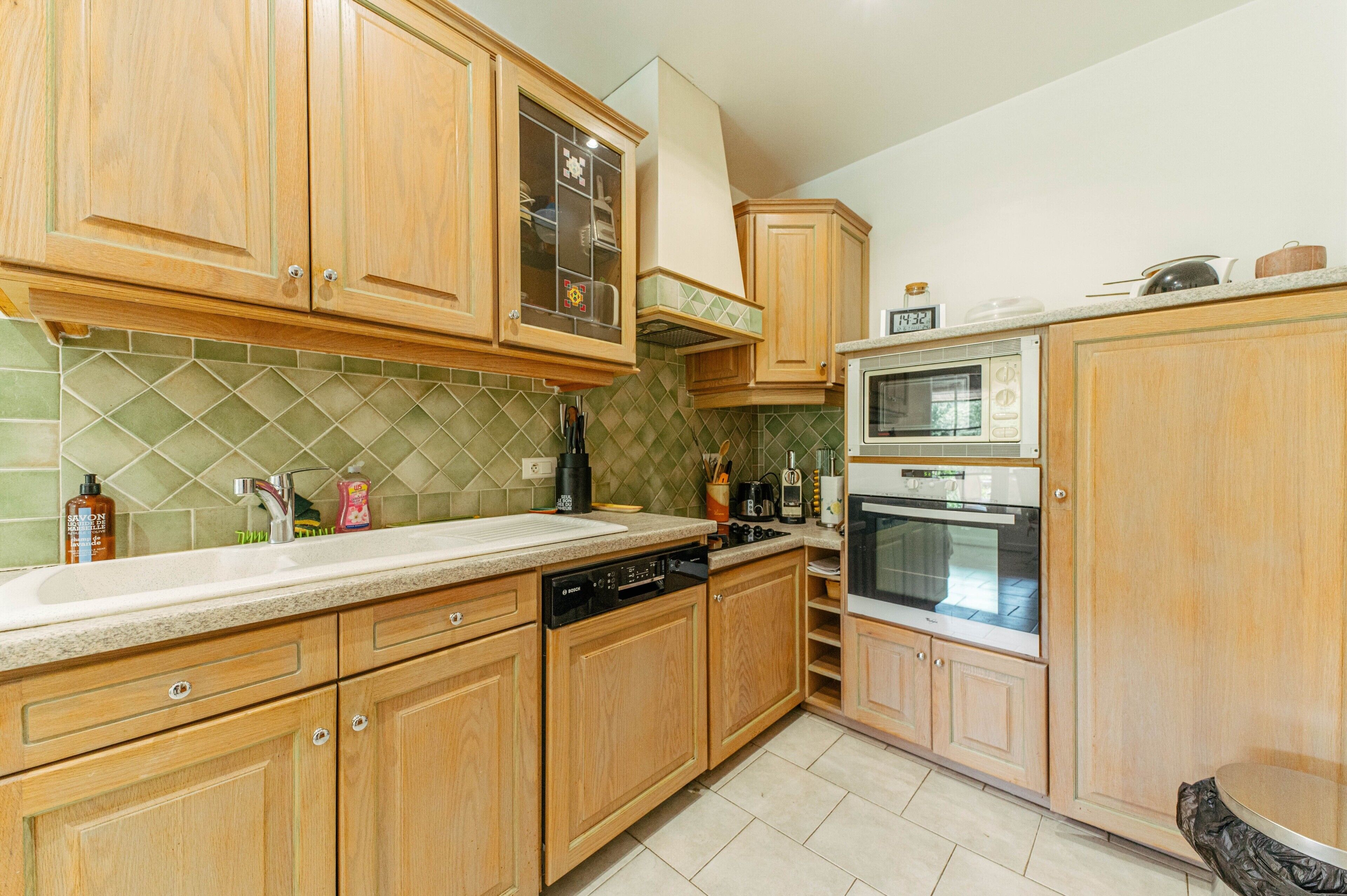 A kitchen with wooden cabinets, a dishwasher, an oven, and a microwave.