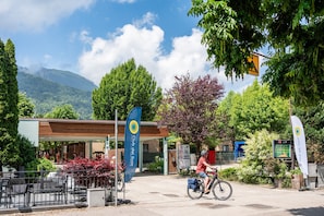 A cyclist riding past a building with a sign that reads "Chalet de Sola." - Mobile Home at Lake Caldonazzo (Pergine Valsugana)