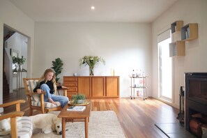 Een ruime woonkamer met een houten kast, een open haard en een groot raam.