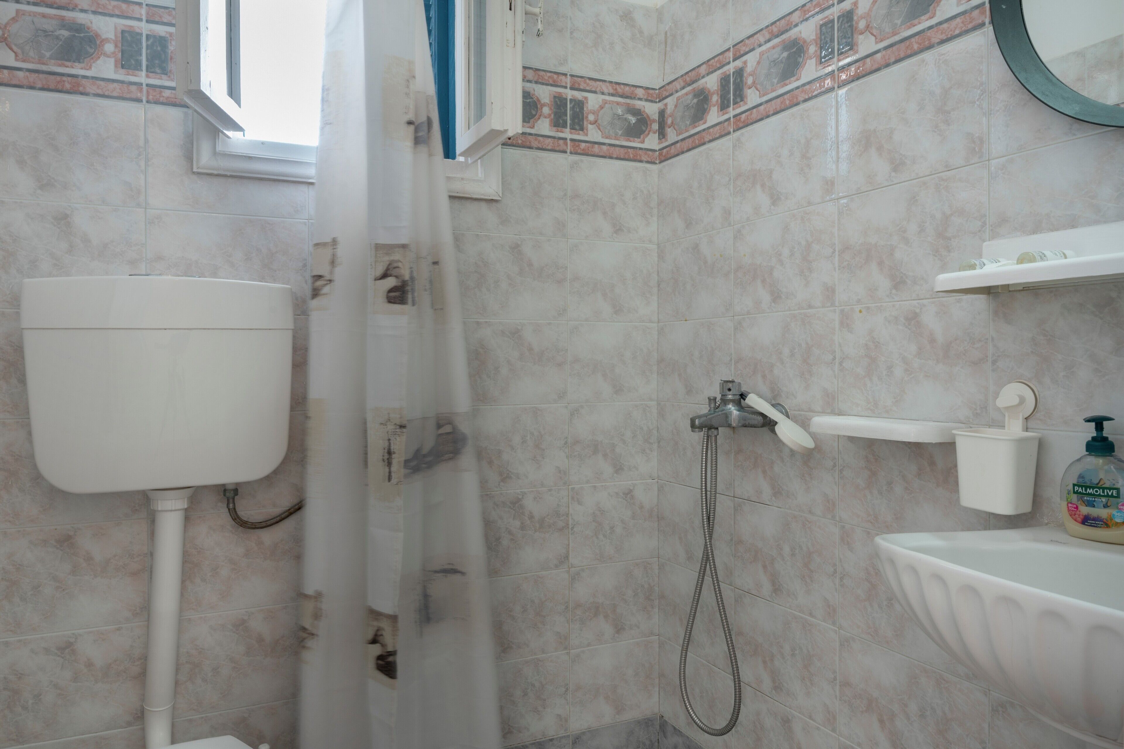 Une salle de bain équipée de toilettes, d’une douche et d’un lavabo.