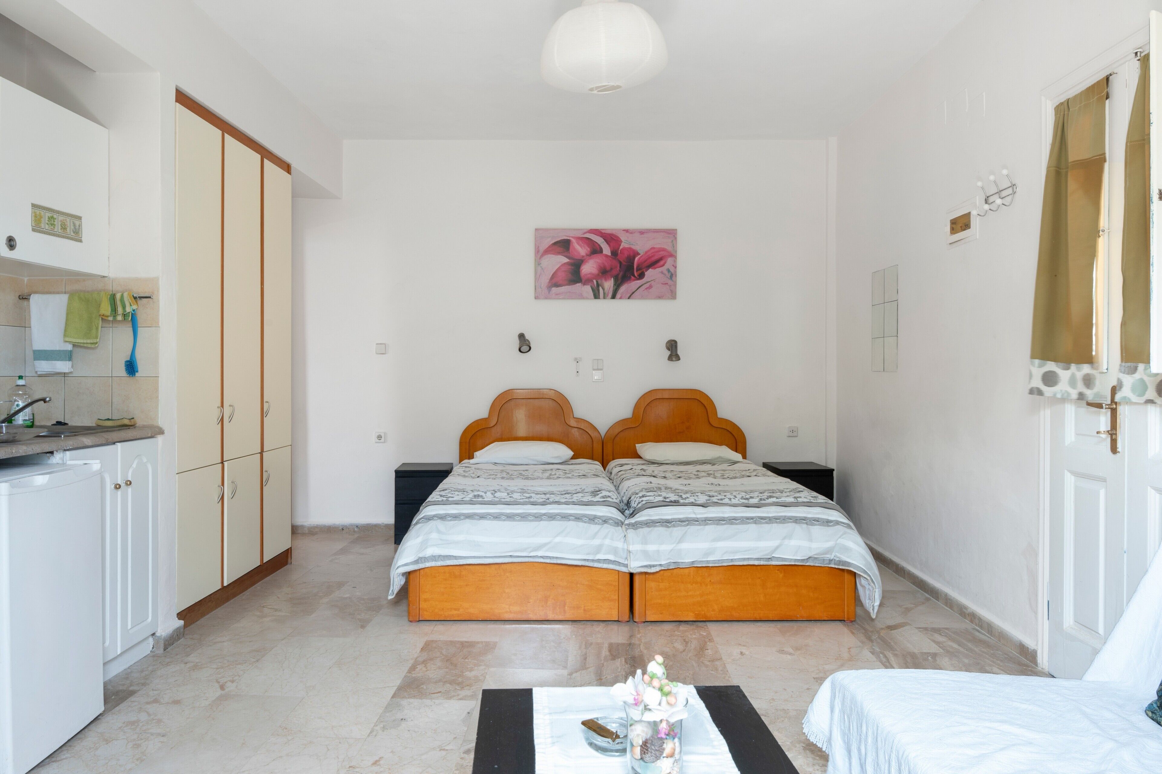 Un dormitorio con dos camas, baño y kitchenette.