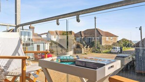 A balcony with a view of houses and a parked car. - Beachside Coastal Retreat with Ocean Views (Pevensey Bay)