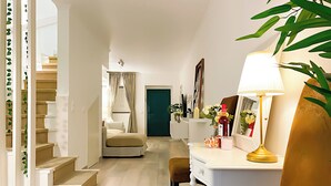 Een moderne woonkamer met een trap, een wit bureau met een lamp en een bank.