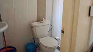 Ein kleines Badezimmer mit Toilette, Waschbecken und Duschvorhang.