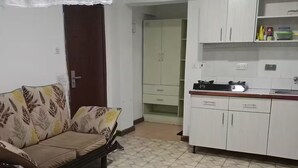Un dormitorio con cama, sofá y kitchenette.