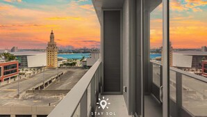 A balcony with a city view, a tall building, and a clear sky. - City Views with Bright 1BR Refined in 501 Miami (Miami)