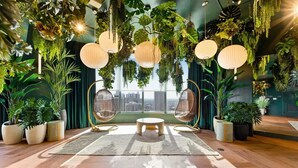 A room with a city view, hanging plants, and two hanging chairs. - City Views with Bright 1BR Refined in 501 Miami (Miami)