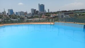 Piscina com paisagem urbana ao fundo.