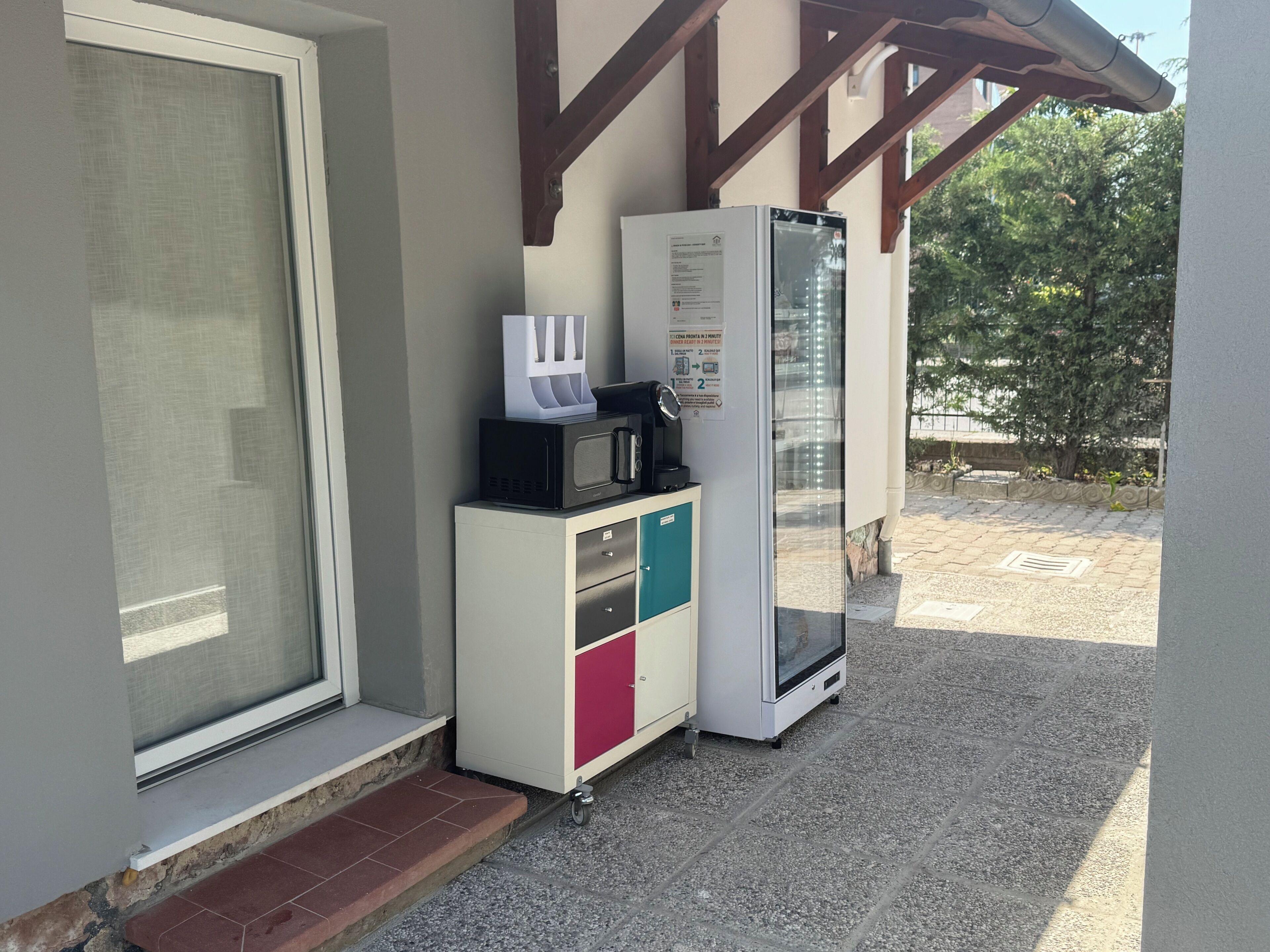 A kitchenette with a microwave, coffee maker, and refrigerator.
