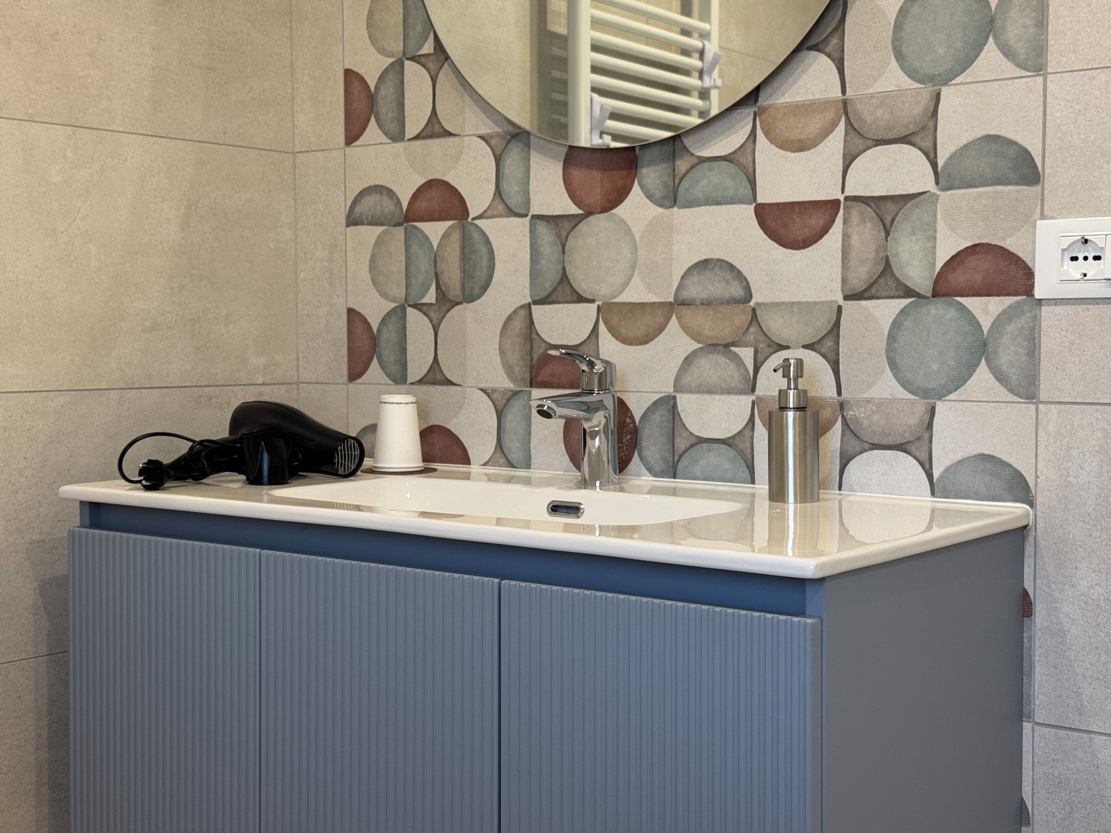 A bathroom with a sink, mirror, and towel rack.