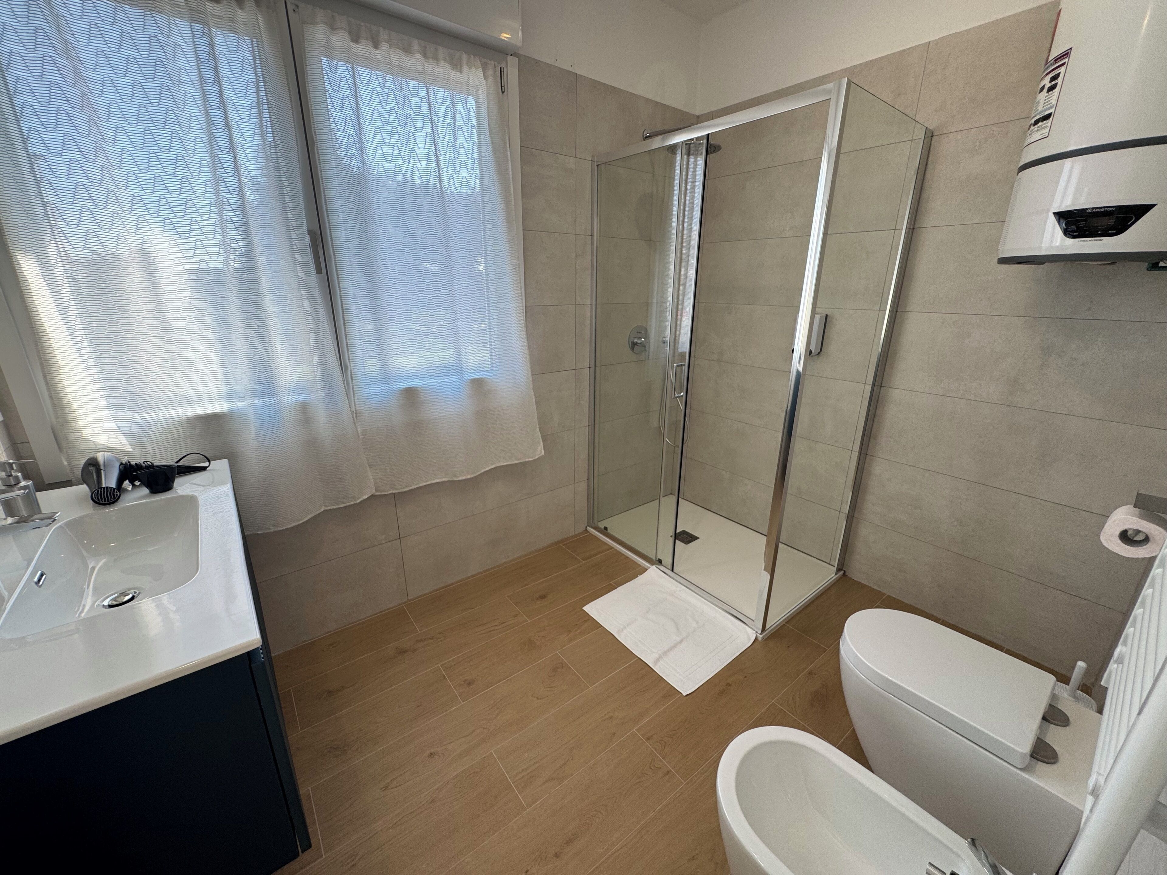 A bathroom with a shower, toilet, and sink.