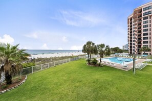 A hotel with a pool, a view of the beach, and a well-maintained lawn. - 🌞Beachfront 3BR w/ Community Pool | Gulf Views from Balcony | Sunswept 201🌞 (Orange Beach)