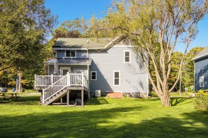 A two-story house with a front porch and a small staircase leading to the entrance.