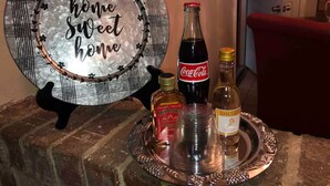 A decorative plate with "home sweet home" text, a bottle of Jack Daniel's, and a bottle of DirecTV on a tray.