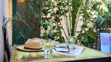 A table with a straw hat, glasses, a newspaper, and a glass of water.