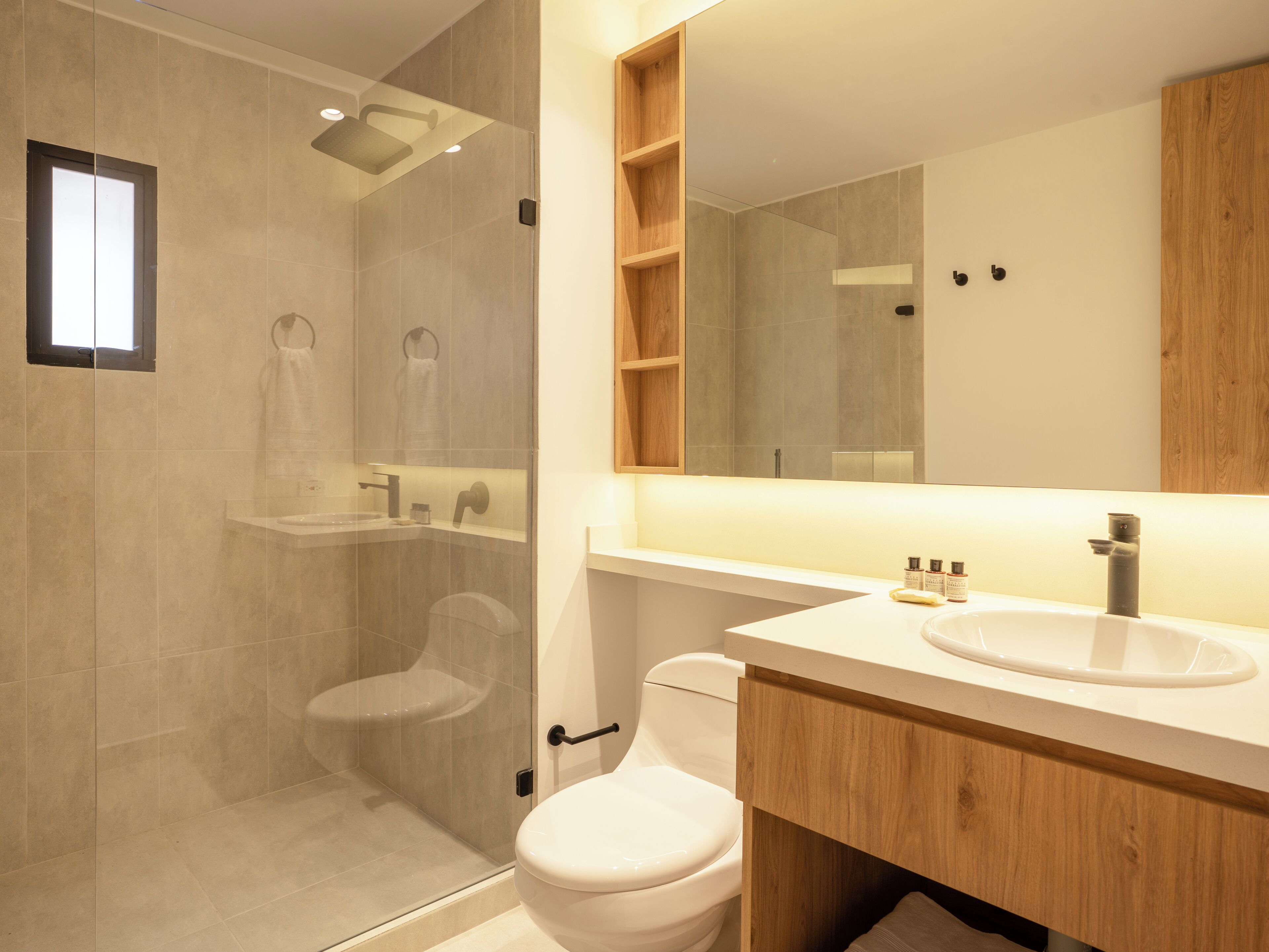 A modern bathroom with a shower, toilet, and sink.