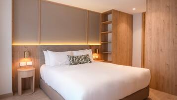 A modern bedroom with a large bed, wooden paneling, and built-in shelving.